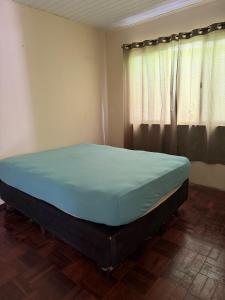 a large bed in a room with a window at Casa de temporada in Camboriú