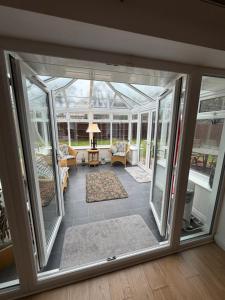 a conservatory with glass doors and a living room at Hillhouse in Hythe