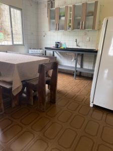 a kitchen with a table and a refrigerator at Casa de temporada in Camboriú