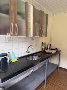 a kitchen with a sink and a counter top at Casa de temporada in Camboriú