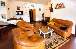 a living room with two leather couches and a table at White Hill Villa in Nuwara Eliya