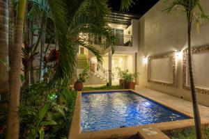 a swimming pool in the garden of a house at night at Hotel Bernardino in Valladolid
