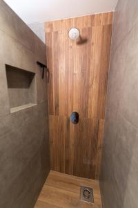 a shower with a wooden door in a bathroom at Schoapdiek Huuskes in Overdinkel