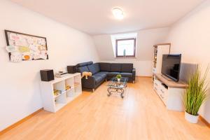 a living room with a couch and a tv at Mosel-Refugium Nr 5 in Zell an der Mosel