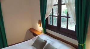 a bedroom with a bed and a window with green curtains at Hotel Zapata in La Cumbre +36 photos