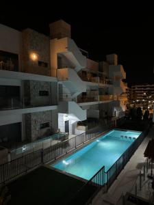 a building with a swimming pool at night at Sunny rest at Pedro's by PORT Holiday Rental in Arenales del Sol