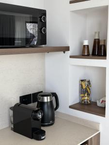a kitchen counter with a microwave and a coffee maker at Villa Ada in Taormina