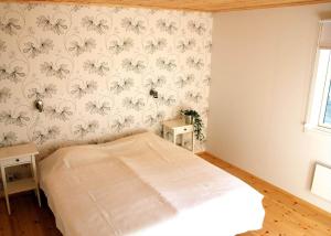 a bedroom with a bed with flowers on the wall at JON404-Skillingaryd-Galtas in Skillingaryd