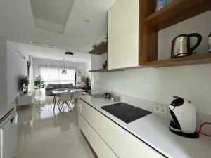 a kitchen with white cabinets and a dining room at Sunny rest at Pedro's by PORT Holiday Rental in Arenales del Sol