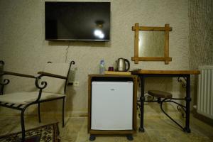 a room with a chair and a tv on the wall at Nirvana Cave House in Avcılar