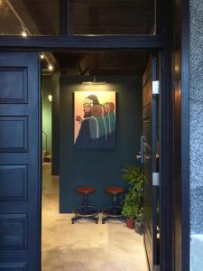 a hallway with two stools and a painting on the wall at MIAOKO Hostel in Dahan