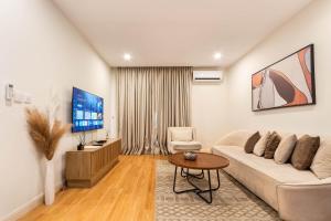 a living room with a couch and a tv at Aima Apartments in Lagos