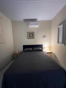 a bedroom with a large bed in a white room at Casa do Sal in São Luís