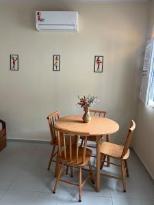 a dining room table with chairs and a vase with flowers at Casa do Sal in São Luís