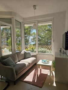 a living room with a couch and two windows at Inas Place in Baška Voda