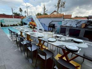 a long table with chairs and plates on it next to a pool at NY grand villa in Nong Prue