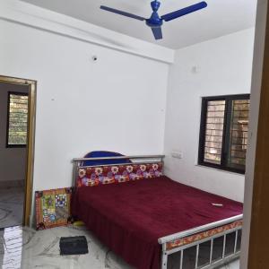 a bedroom with a bed with a ceiling fan at shreejikunj in Bolpur +11 photos