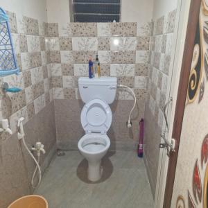 a bathroom with a white toilet in a room at shreejikunj in Bolpur