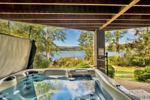 a tub with a view of a lake at Lakefront Sunsets, Hot Tub, Pool Table, Kayaks in Lake Ariel