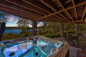 a hot tub on a patio with a view of a lake at Lakefront Sunsets, Hot Tub, Pool Table, Kayaks in Lake Ariel +71 photos