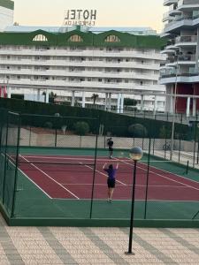 a woman is playing tennis on a tennis court at Costa Relax Beach Apartment with Pool & Tennis in Ifach