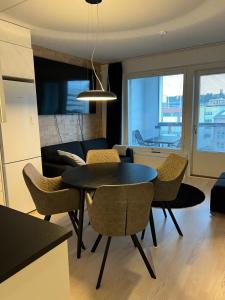 a dining room and living room with a table and chairs at Moderni Kaksio -Huippu sijainti! in Jyväskylä