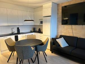 a living room with a table and a couch at Moderni Kaksio -Huippu sijainti! in Jyväskylä