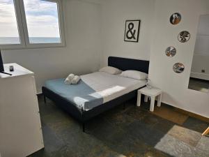 a small bedroom with a bed and a window at Blife Charlya private rooms at Faro beach in FAO