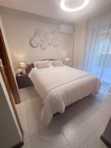 a bedroom with a large white bed and a window at Costa Relax Beach Apartment with Pool & Tennis in Ifach +51 photos