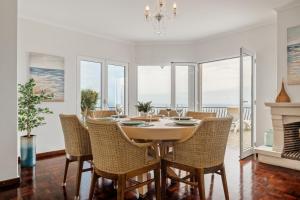 a dining room with a table and chairs and a fireplace at Villa Amor Do Mar -180° Sea View, Jacuzzi,Terrace in Funchal