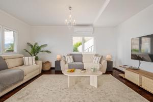 a living room with a couch and a table at Villa Amor Do Mar -180° Sea View, Jacuzzi,Terrace in Funchal