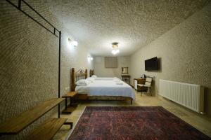 a bedroom with a bed and a table and a couch at Nirvana Cave House in Avcılar