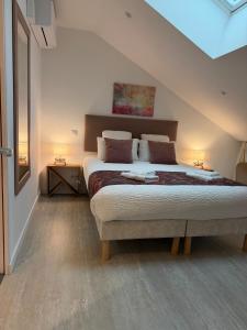 a bedroom with a large bed in a attic at La Belle Cachette in Matougues