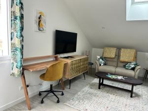 a living room with a desk and a couch at La Belle Cachette in Matougues