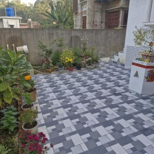 a courtyard with potted plants and flowers at shreejikunj in Bolpur
