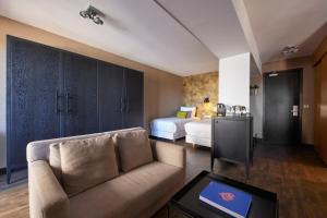 a living room with a couch and a bed at Van der Valk Hotel Saint-Aygulf in Saint-Aygulf +73 photos
