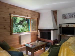 a living room with a couch and a fireplace at Lou Rigal in Dourbies