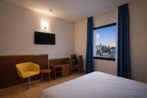 a hotel room with a bed and a desk and a window at LVG Hotel Collection - Gardenia in Verona