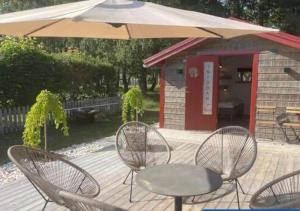 a table and chairs under an umbrella on a deck at HAL908-Skummesloevsstrand-Rundan-37 in Skummeslövsstrand