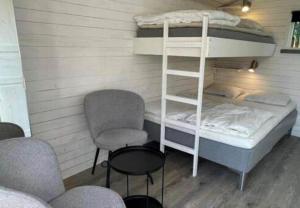 a room with a bunk bed and a chair at HAL908-Skummesloevsstrand-Rundan-37 in Skummeslövsstrand