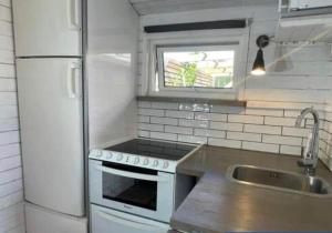 a kitchen with a white refrigerator and a sink at HAL908-Skummesloevsstrand-Rundan-37 in Skummeslövsstrand