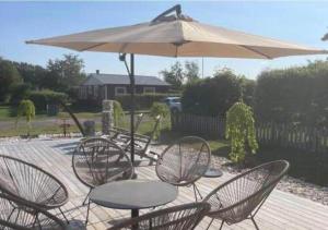 a group of tables and chairs under an umbrella at HAL908-Skummesloevsstrand-Rundan-37 in Skummeslövsstrand +14 photos