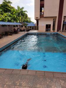 a swimming pool in front of a building at Valencia Hotels Abuja in Abuja