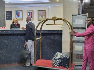 a man standing next to a luggage cart in an airport at Valencia Hotels Abuja in Abuja +12 photos