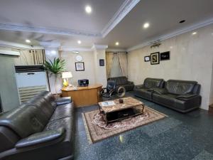 a living room with leather couches and a coffee table at Valencia Hotels Abuja in Abuja