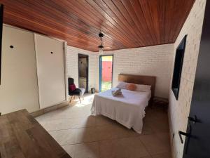 a bedroom with a bed and a person sitting in a chair at Iago Pousada in Cabo Frio +50 photos