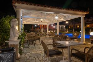 a pavilion with tables and chairs and a pool at Regina Nina in Vasilátika