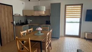 a kitchen and dining room with a table and chairs at Apartamenty Polna Ostoja in Tylicz +16 photos