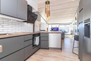 a kitchen with stainless steel appliances and wooden ceilings at HAL901-Skummesloevsstrand-Rundan-37 in Skummeslövsstrand