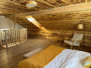 a bedroom with a bed and a chair at Apartamenty Polna Ostoja in Tylicz